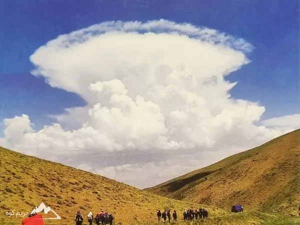 ابر بزرگ کومولوس بالای یک تپه سبز
